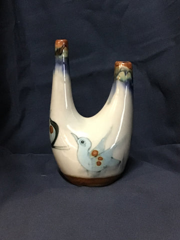 Ceramic bottle with bird design on a dark blue background