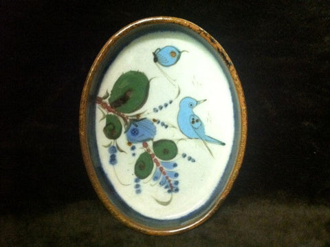 Round stoneware tray with brown rim and bird and butterfly inside.
