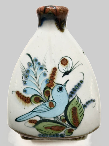A vase with brown top trim and a bird, butterfly and plants.