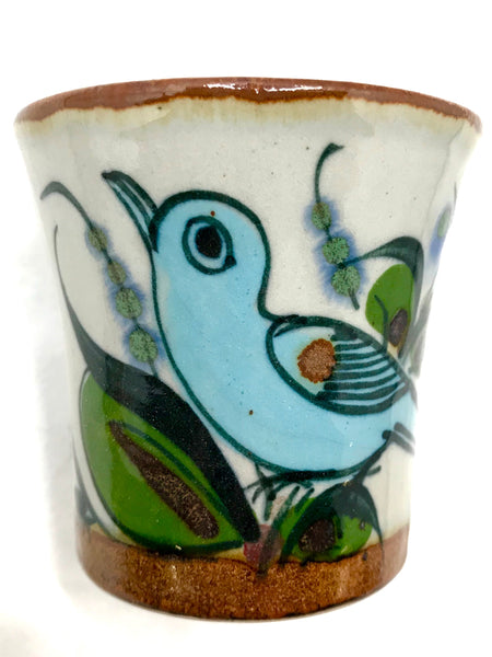 Ken Edwards stoneware mini drinking cup with  green, two shades of blue and brown flowers, birds, and butterflies decorated on the side or inside on bowls or plates