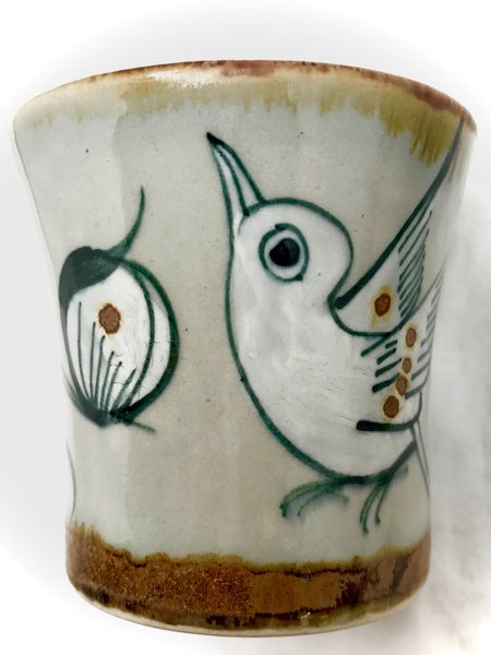 Ken Edwards stoneware mini drinking cup with green, two shades of blue and brown flowers, birds, and butterflies decorated on the side or inside on bowls or plates