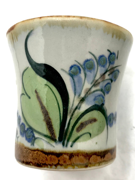 Ken Edwards stoneware mini drinking cup with green, two shades of blue and brown flowers, birds, and butterflies decorated on the side or inside on bowls or plates