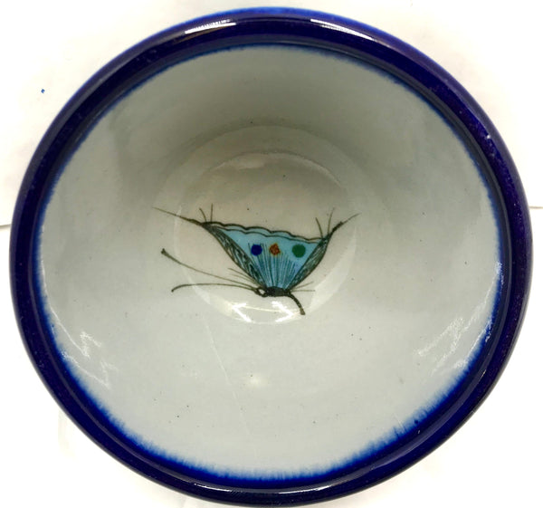 Ken Edwards collection series custard bown with blue rim. It is natural grey clay color background with birds, butterflies, and leaves in blue, green, black and brown on the outside.