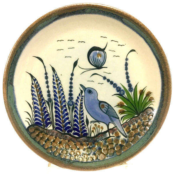 Ken Edwards Stoneware Pottery trivet with green, two shades of blue and brown flowers, birds, and butterflies decorated on the side or inside on bowls or plates 