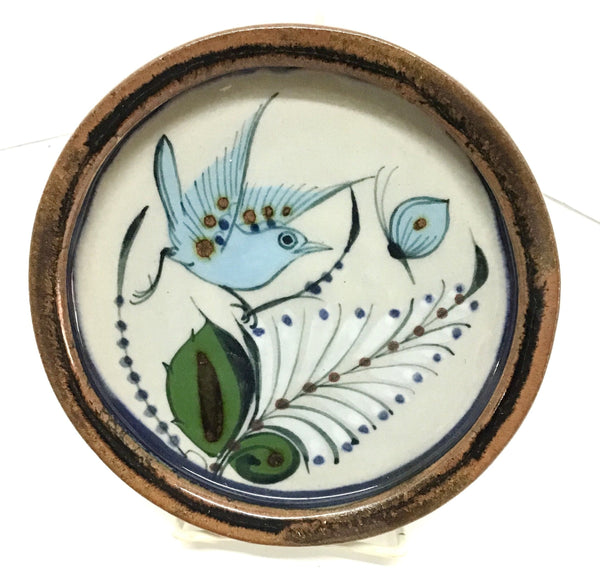Ken Edwards Pottery trivet with brown trim and bird and butterfly and leaves in blue, green and black.