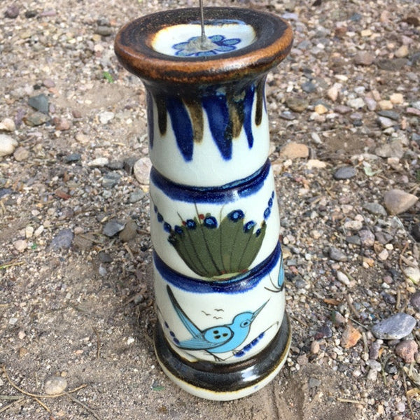 Banded candle holder for one thick candle .  Brown rim with blue bands and light blue bird.