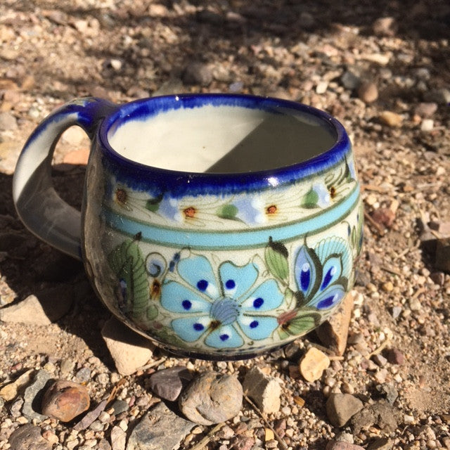Ken Edwards Collection series coffee mug.  Blue rim with green, two shades of blue and brown flowers, birds, and butterflies decorated on the side or inside on bowls or plates.