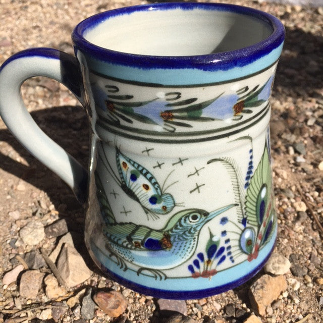 Ken Edwards Collection Coffee or Tea mug with green, two shades of blue and brown flowers, birds, and butterflies decorated on the side or inside on bowls or plates 